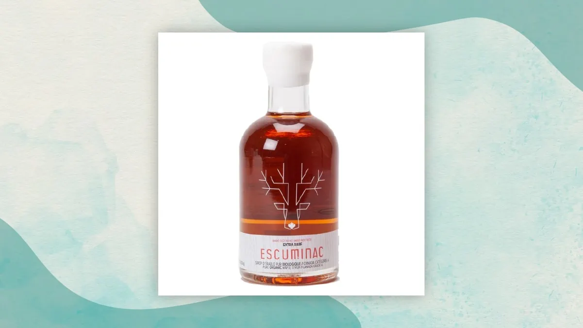 A bottle of maple syrup with "ESCUMINAC" branding in a white background. It's one of the best gifts for long distance relationships. 