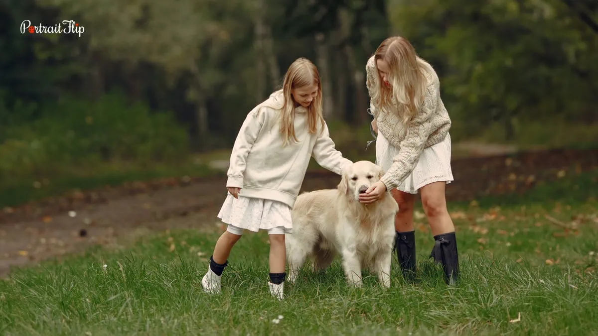 two girls posing with their dog