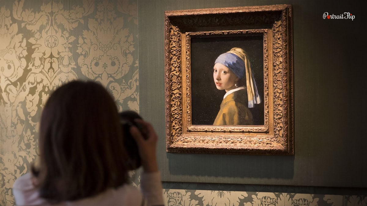 Lady clicking picture of the famous painting Girl with Pearl Earring