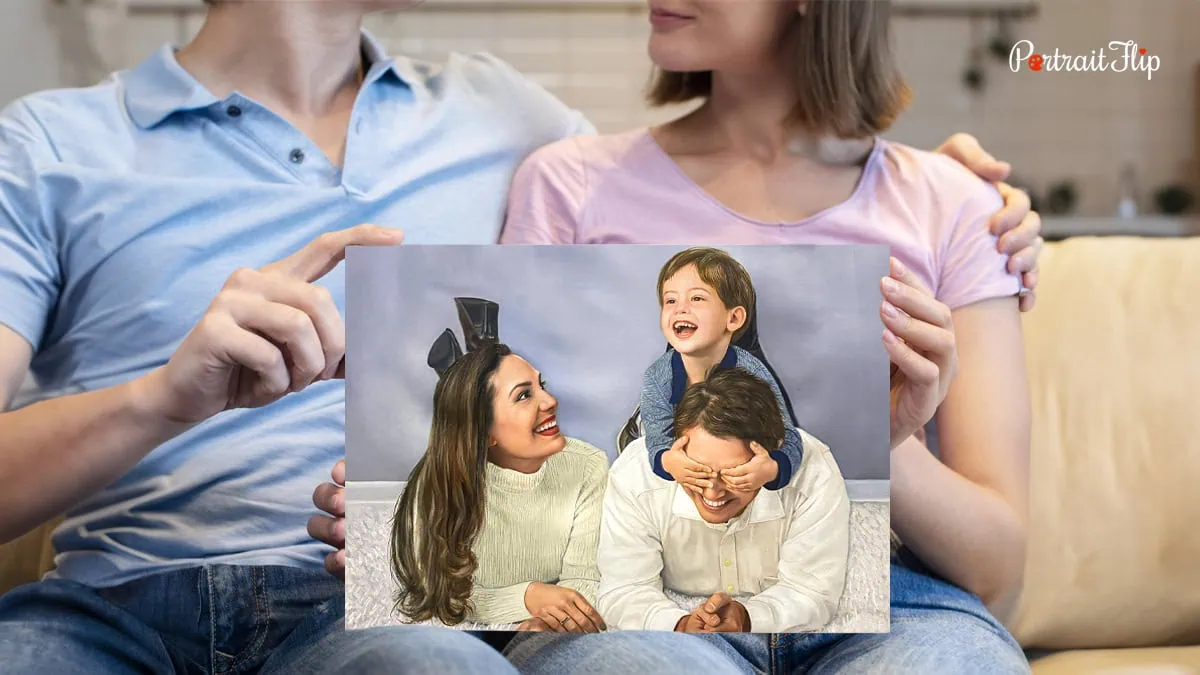 a couple holding their family portrait on their lap.