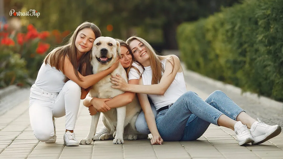 photo of three girls with their dog