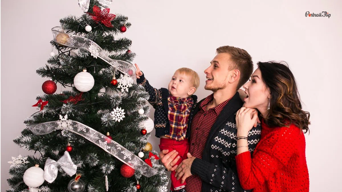 a family next to a christmas tree
