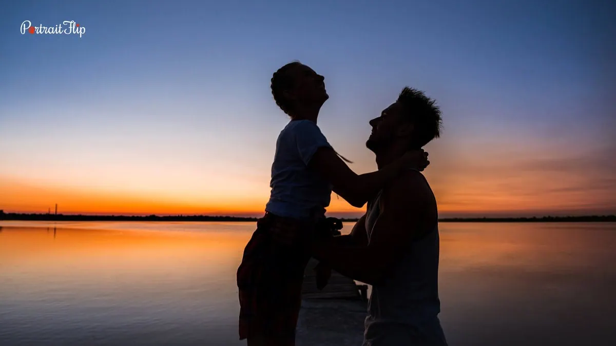 This image shows a man lifting a woman in his arms