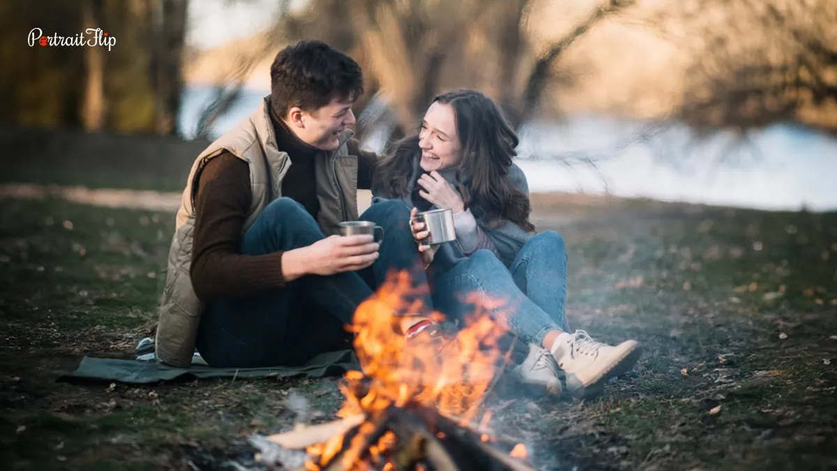 This image shows a young couple near a campfire